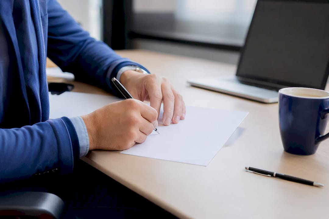 Mains en train de signer un contrat dans un bureau moderne